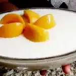 Gelado de pêssego cremoso e refrescante, combinando a leveza do creme com pedaços da fruta 1 Gelado de pêssego cremoso