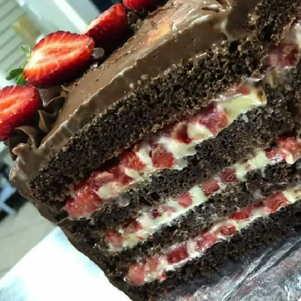 Bolo de chocolate com recheio de leite ninho com morango